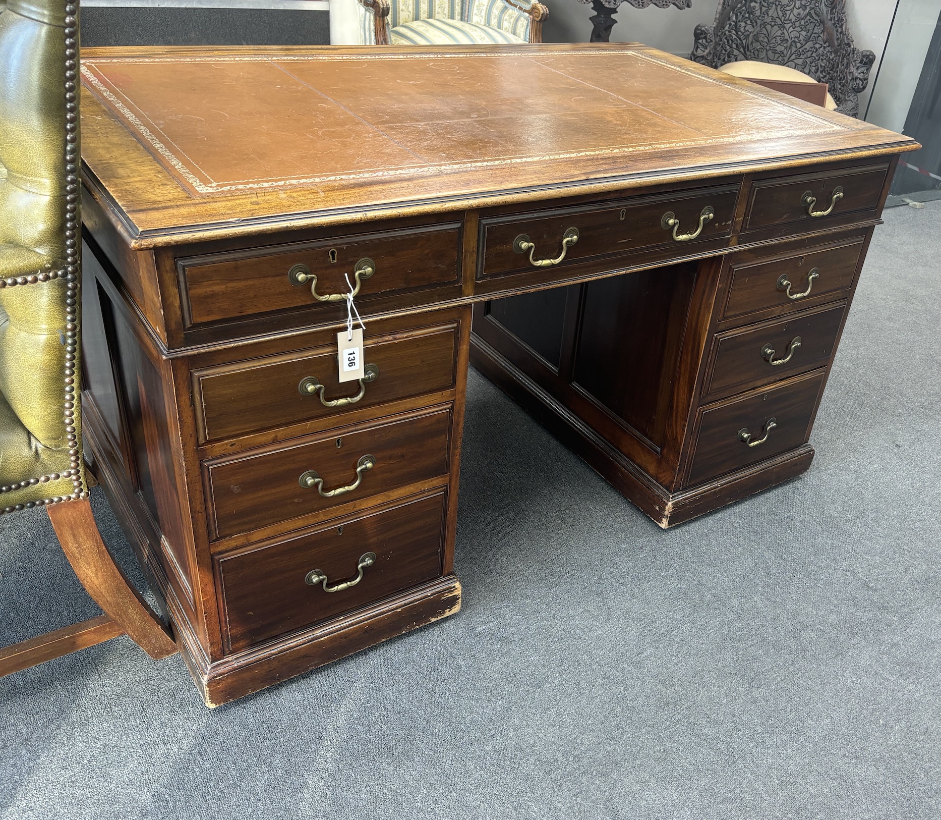 A George III style mahogany pedestal desk, width 138cm, depth 83cm, height 77cm together with a Gainsborough style buttoned green leather elbow chair